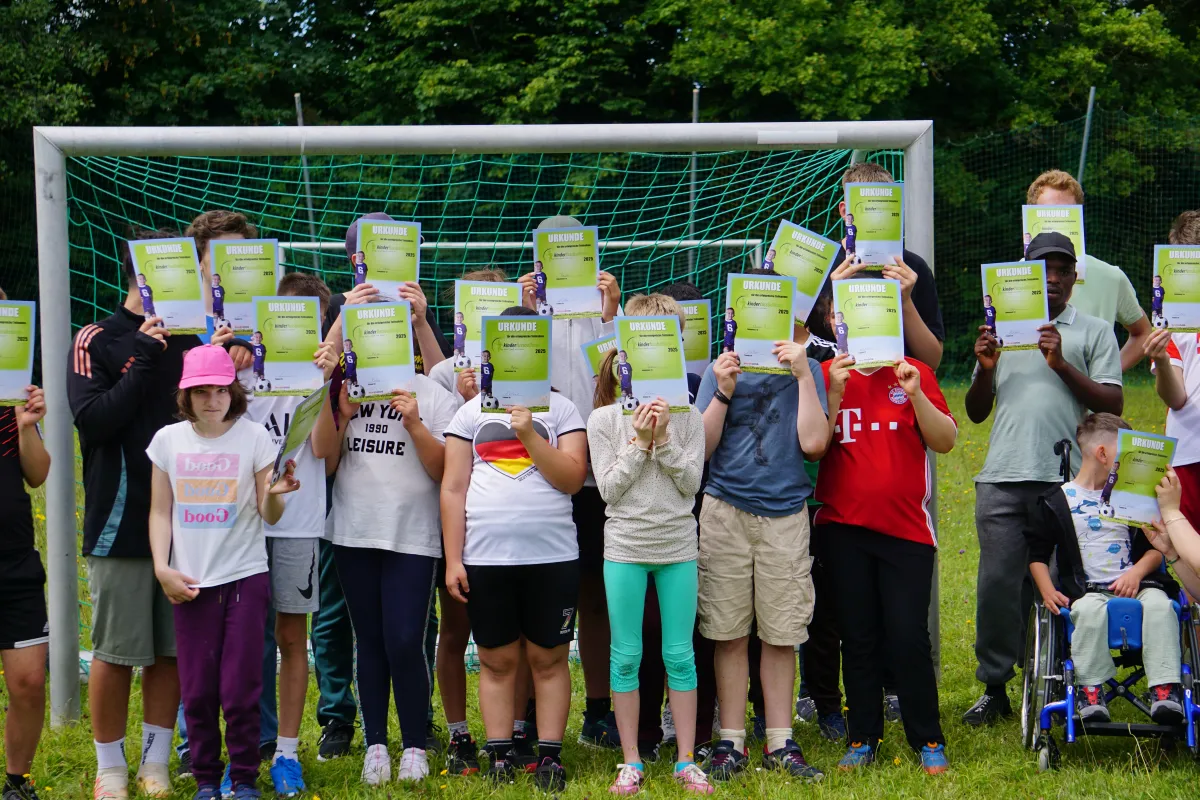 Gruppenfoto einer Fu&szlig;ballmannschaft vor einem Fu&szlig;balltor