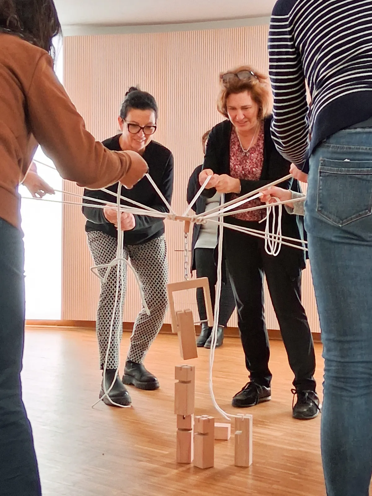 Mehrere Menschen beim Bau eines Turms aus Holzklötzen