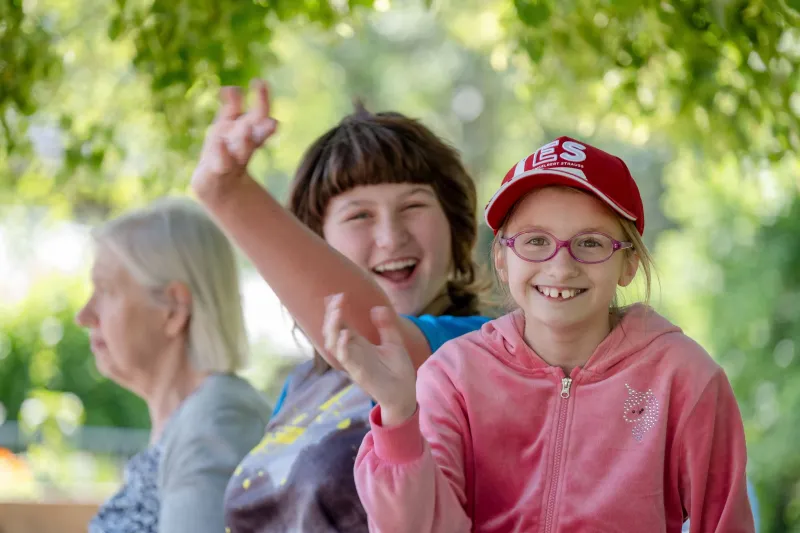 Zwei M&auml;dchen lachen und winken
